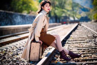 青年女人坐在铁轨上