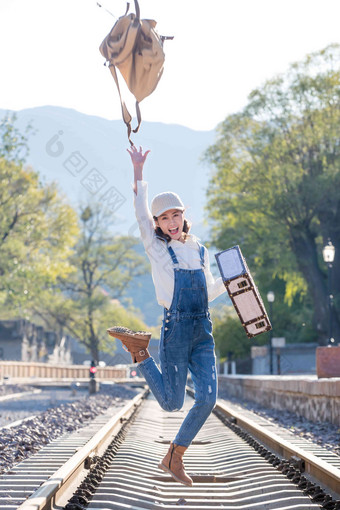 青年女人在铁轨上跳跃