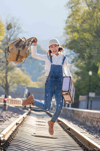 青年女人在铁轨上跳跃探险清晰摄影图