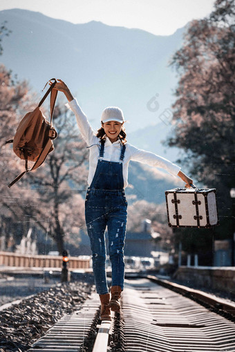 青年女人在铁轨上行走