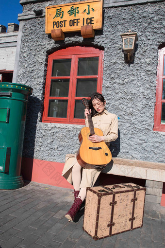青年女人坐在户外弹吉他旅途高清摄影图