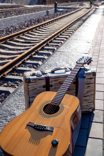 铁轨旁边的吉他和旅行箱