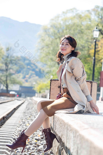 青年女人坐在铁轨旁边