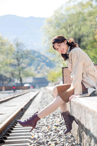 青年女人坐在铁轨旁边郊游图片