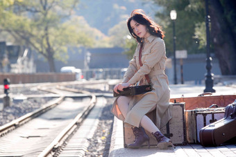 青年女人坐在火车站站台上旅行箱清晰摄影