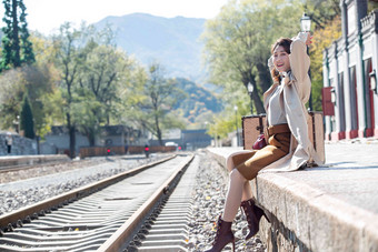 青年女人坐在铁轨旁边