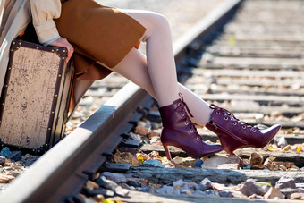 青年女人坐在铁轨上