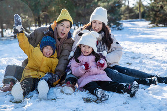 快乐的一家人坐在<strong>雪地</strong>上寒冷的写实拍摄
