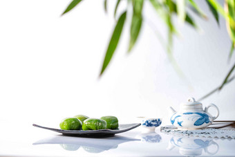 竹叶下的青团和茶具美食高质量摄影