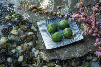水面上的<strong>青团</strong>和桃花中国食品氛围摄影