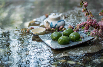 水面上的青团和茶具中华美食高端图片