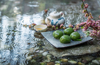 水面上的青团和茶具饮食文化高质量摄影