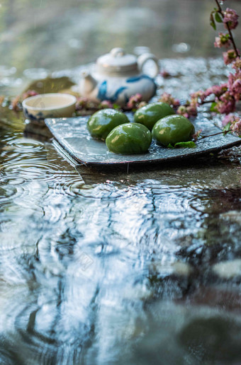 雨中盘子里的青团和茶具清新高质量场景