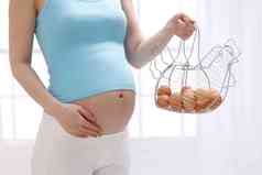 孕妇拿着一筐鸡蛋