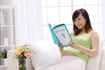 孕妇看书倚靠清晰摄影图