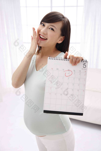 孕妇拿着日历牌