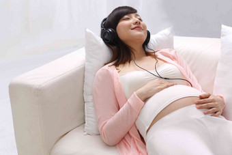 孕妇躺在沙发上听音乐