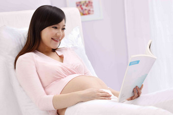 孕妇坐在床上看书坐着高端场景