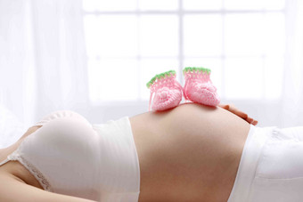 <strong>婴儿</strong>袜子放在孕妇的肚子上