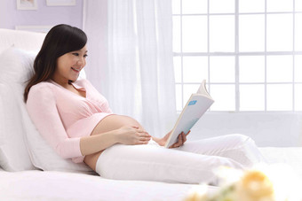 孕妇坐在床上看书睡衣清晰摄影