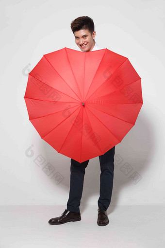 青年男人拿着心形红雨伞