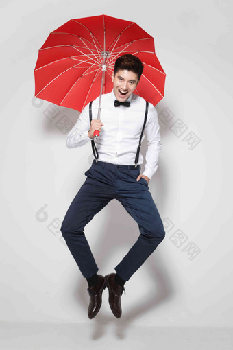 青年男人拿着红雨伞跳跃打开图片