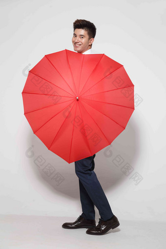 青年男人拿着心形红雨伞情人节氛围场景