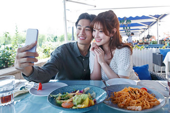 快乐情侣在餐厅里用餐食品高质量照片