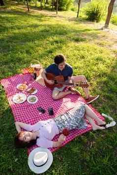 在公园里弹吉他的幸福情侣