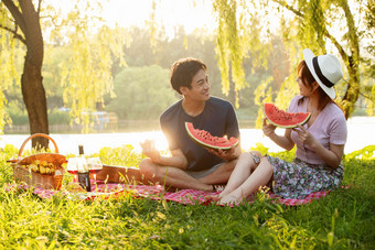 青年<strong>情侣</strong>坐在公园里吃西瓜