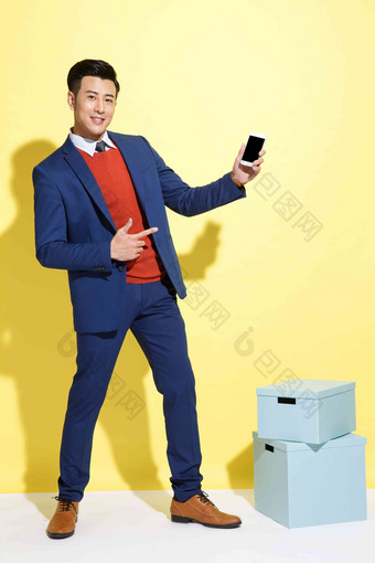 青年商务男士展示手机黄色背景高质量摄影图