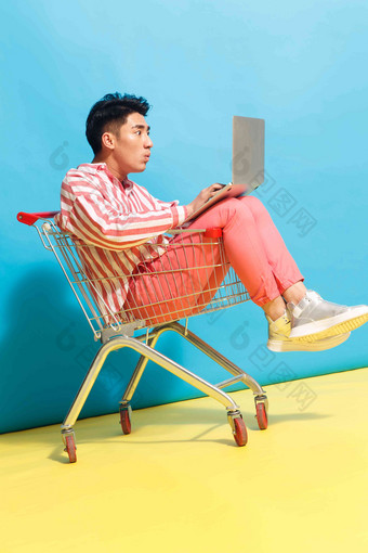 青年男人坐在购物车里用笔记本电脑亚洲清晰相片