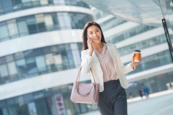 青年商务女人边走边打电话水平构图照片