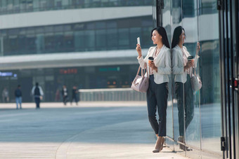 青年商务女人站在户外看手机互联网高质量素材