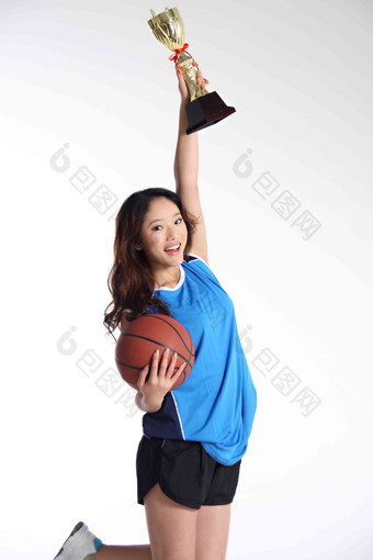东方青年女篮球运动员高举奖杯概念高端摄影图