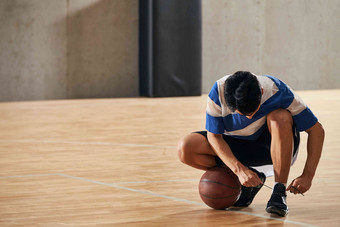 青年男人在<strong>篮球</strong>场上系鞋带