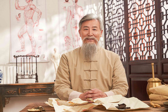 老中医坐在药桌后的肖像中国元素写实摄影图