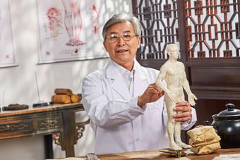 老中医拿着人体针灸穴位模型中国元素摄影图