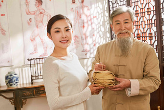 老中医和病人拿着药包的肖像中国元素照片