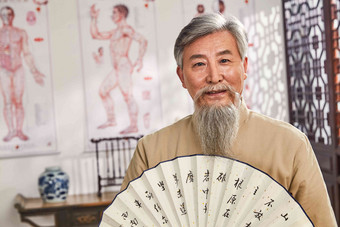 老中医拿着扇子的肖像中国元素摄影图