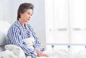 老年患者坐在医院病床上彩色图片氛围场景