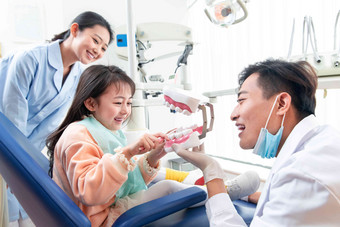 牙科医生教小女孩刷牙三个人高清拍摄