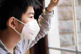 戴口罩的男孩透过窗户往外看空气污染氛围相片