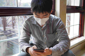 戴口罩的男孩看手机疫情氛围镜头