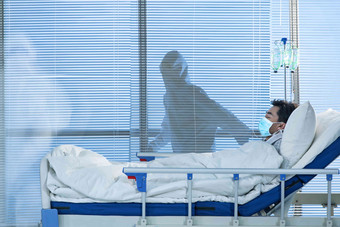 患者躺在医院病床上口罩高质量摄影