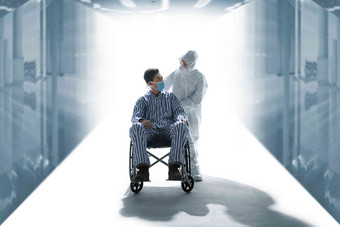 医务工作者推着坐轮椅的患者