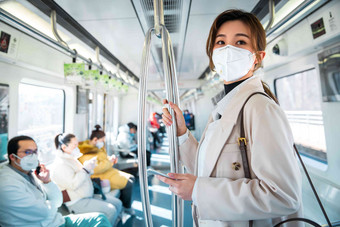 戴口罩的年轻女人乘坐<strong>地铁</strong>绿色出行高清照片