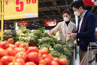 青年夫妇戴口罩在超市挑选蔬菜西红柿高端拍摄