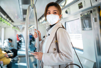 戴口罩的年轻女人乘坐地铁