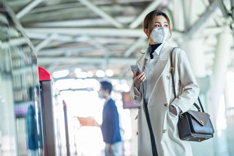 戴口罩的年轻女人站在<strong>地铁</strong>站台上